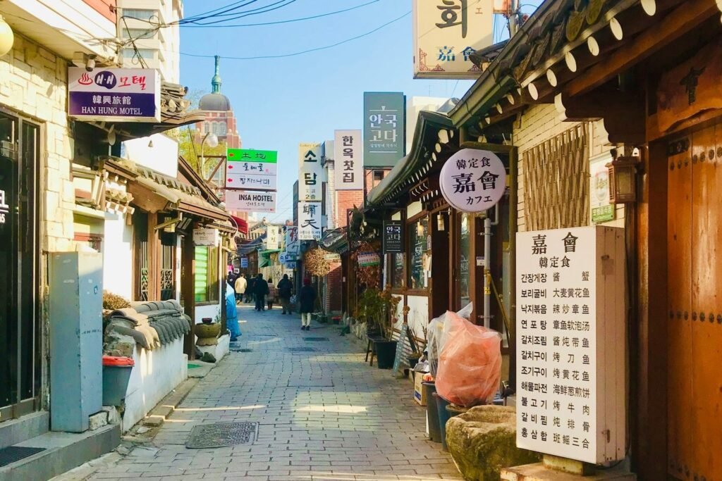 Traditional alley in Insadong, Seoul, with hanok-style buildings, Korean signs and local shops.